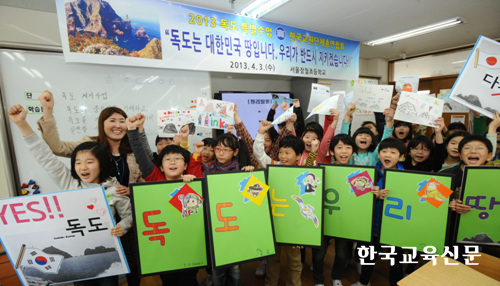 서울 장월초 김용원교사(왼쪽 두번째)와 학생들이 '독도는 우리땅'이 쓰인 피켓과 자신들이 그린 그림을 들어보이며 구호를 외치고 있다.