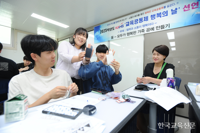 박단비(왼쪽 두 번째) 교사가 2학년 교실에서 진행된 가죽 핸드폰 케이스 만들기에서 학생, 학부모와 함께 완성된 케이스를 들어 보이고 있다.