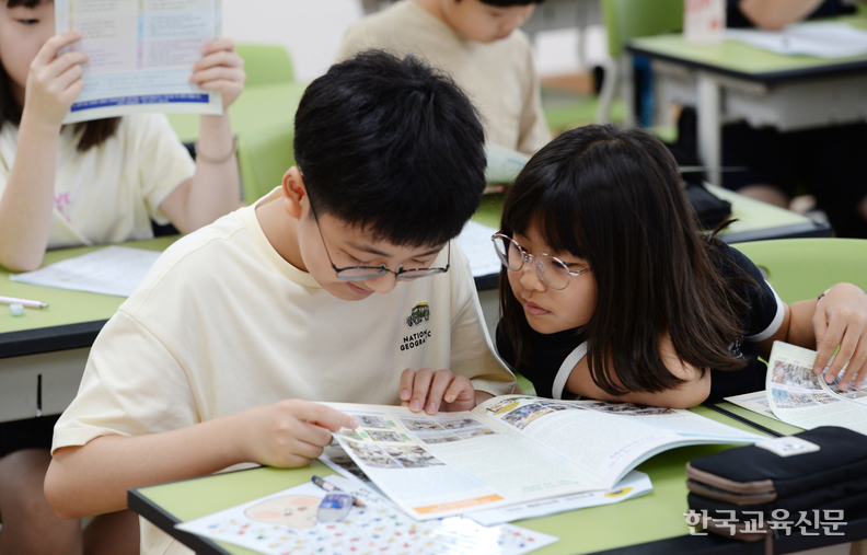 여기 우리 반 나왔다! 방학 안내문에 자신들의 1학기 학생 활동 사진이 나오자 신기한 듯 바라보고 있다.