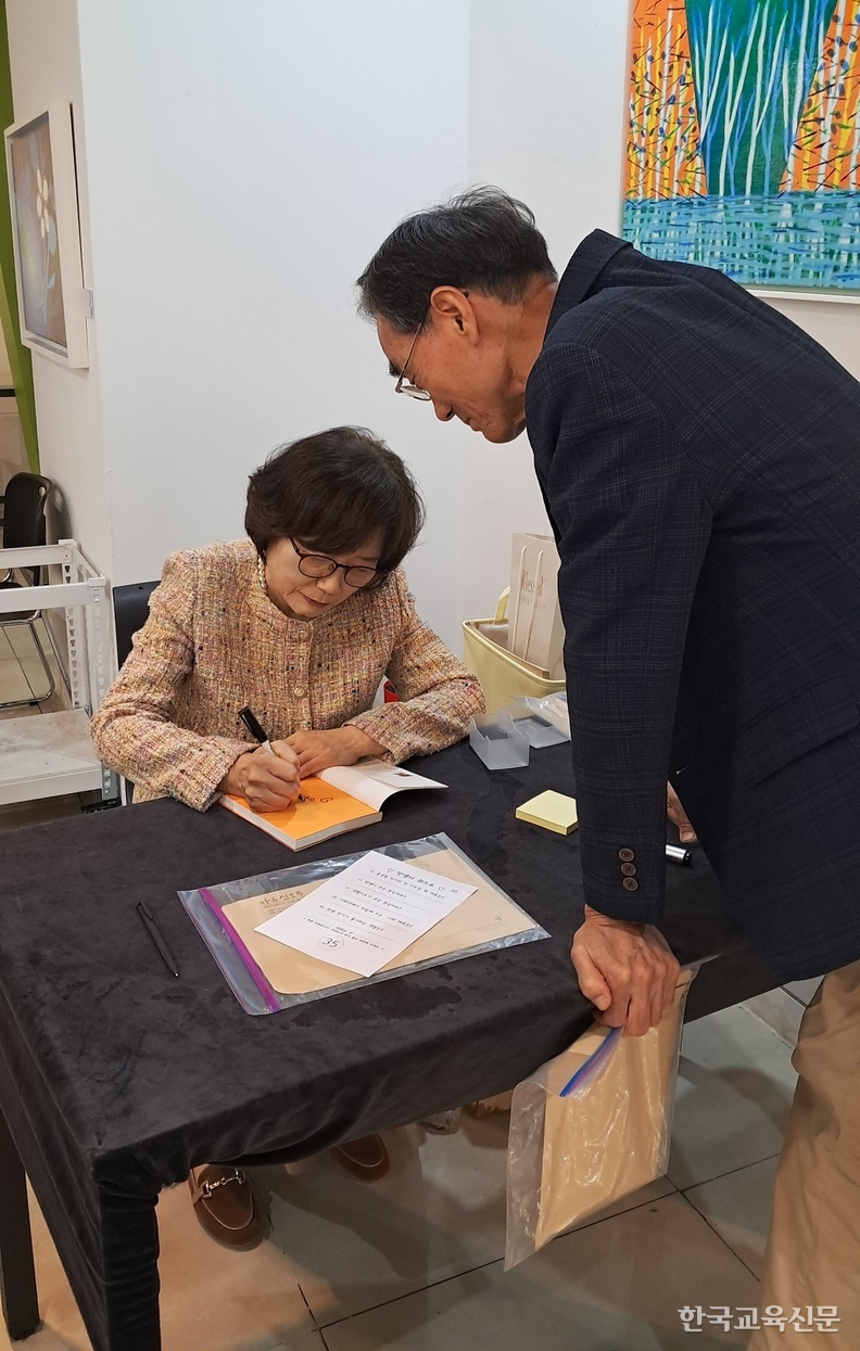 홍 작가가 저자 사인을 정성껏 하고 있다.