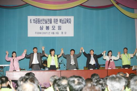 평양시 모란봉제1중학교에서 열린 남북교육자 상봉대회에서 남북 교원단체 대표들이 맞잡은 두손을 치켜들고 통일의 선봉에 설 것을 결의하고 있다.