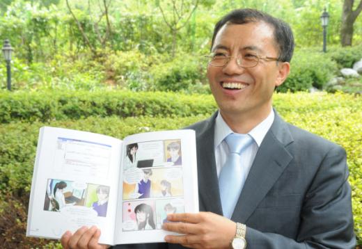 만화로 교직실무를 설명한 저서를 들어 보이는 남정권 교사