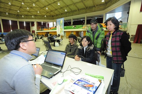 2012 대입박람회장에서 학생과 학부모가 진지한 표정으로 진학상담관의 설명을 듣고 있다