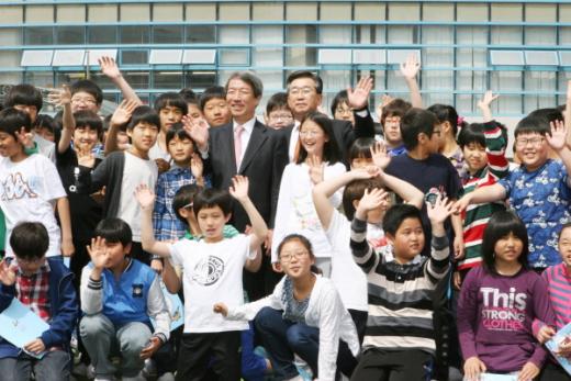 정운찬 전 국무총리와 심은석 서울중곡초 교장이 6학년 학생들과 함께 웃고 있다.