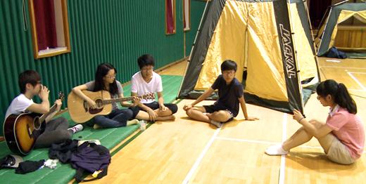 남선진 서울 방학중 교사가 학교에서 진행된 1박2일 야영 중 학생들과 함께 기타를 치고 있다.
