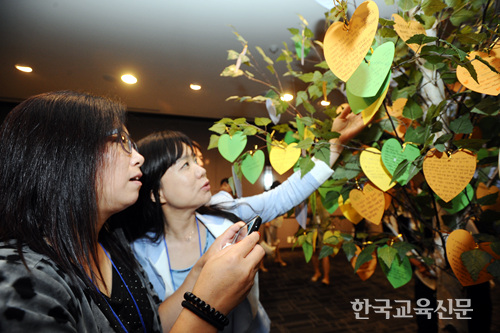 자유학기제 성공을 염원하는 마음을 담은 메세지들이 '소망나무'에 걸려 있다. 다양한 메세지들을 살펴보는 선생님들의 모습.
