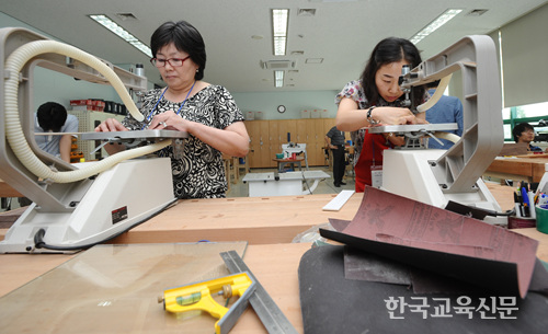 전동 톱을 이용해 전통함 제작에 필요한 재료를 다듬는 교사들의 모습.