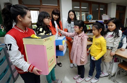 경기 고림초 학생들이 지난달 30일 학생회에서 준비한 모금함에 성금을 기부하고 있다. 이 학교는 사흘간의 모금을 통해 233만 원을 모았다.