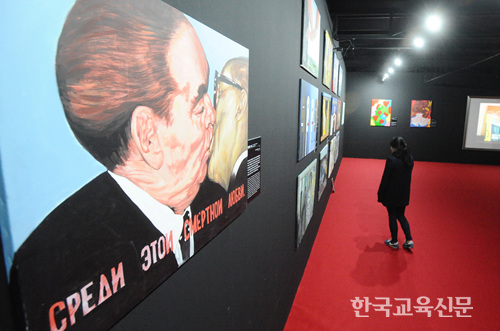 한 여성 관람객이 전시된 그림들을 바라보고 있다.