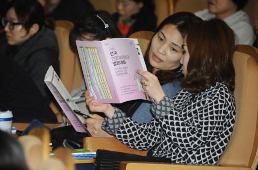 개회식에 참석한 교원들이 리플렛을 살펴보고 있다.