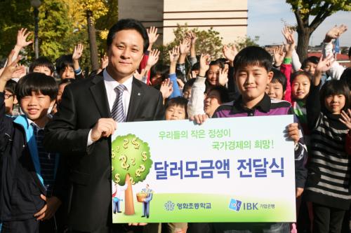 어린이대통령 손상혁군이 그동안 모은 달러를 기업은행관계자에게 전달하고 있다.