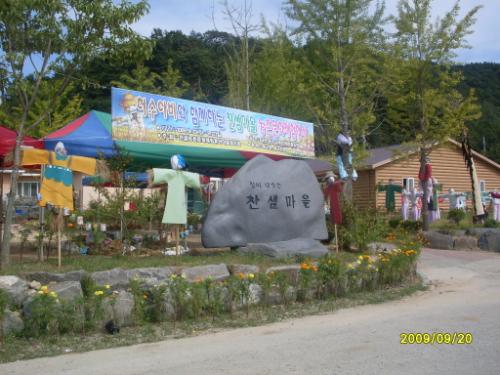 허수아비 축제를 알리는 현수막과 찬샘마을 표지석.