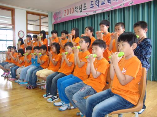 도학가족사랑줄넘기대회 때 학무모들 앞에서 전교생이 오카리나 공연을 하고 있다.