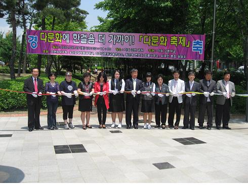 다문화가족축제 개막테이프를 자르고 있다.