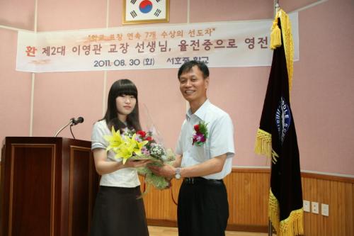 이임식에서 학생회장으로부터 꽃을 전달받는 필자