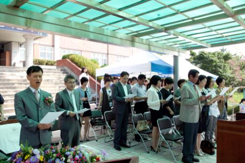 율전중학교 제6대 교장 취임식에서 교가를 부르고 있는 필자(맨 왼쪽). 학부모들도 악보를 보면서 교가를 제창하고 있다.