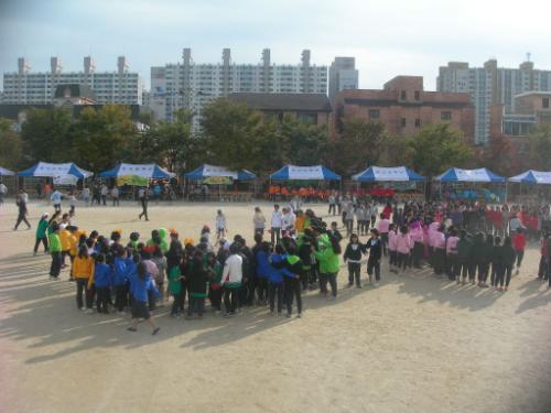 교사와 학생이 함께 참가한 8자 줄넘기. 울타리 너머 인근 빌라와 아파트가 보인다.
