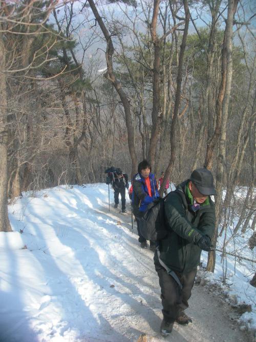 겨울철 산행 눙길이 미끄러워 위험하다. 줄을 잡고 산을 오르는 회원들.