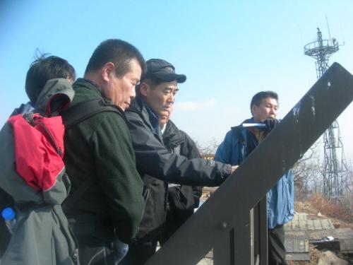칠갑산 정상에서 지리를 살펴보고 있는 회원들