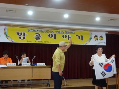 우리 고장 '밤골 이야기'에 태극기 아줌마와 동장이 등장하여 연기를 펼치고 있다. 모자 쓴 사람은 실제 율천동장 김현광씨.