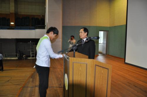 Healing 학생봉사동아리 결의문을 낭독한 뒤 김진우 학생회부회장이 결의문을 김동민 교장선생님께 헌정하고 있다.