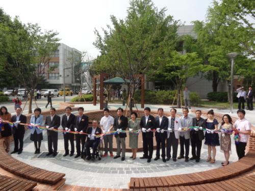 야외학습장에서 내빈들이 기념 테이프를 자르고 있다.