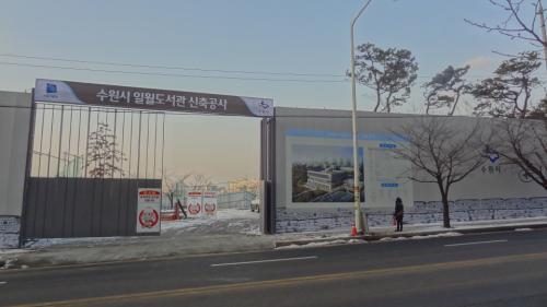 주민이 일월도서관 조감도와 신축공사 내용 알림판을 살펴보고 있다.