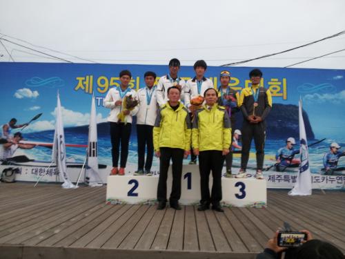 충남 서산 서령고 카누선수들이 우승 후, 김동민 교장선생님과 김덕수 총동창회장과 함께, 시상대에서 환하게 웃고 있다.