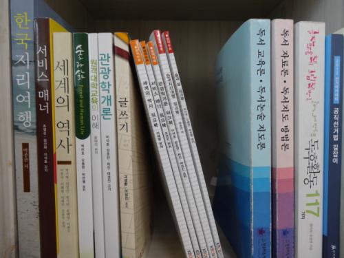방송대 교과서가 책장의 일부를 차지하였다. 졸업을 하려면 교과서가 책장의 8칸을 차지해야 한다.